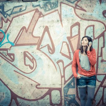 Beautiful stylish woman listening to music in the street