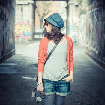 Beautiful stylish woman listening to music in the street