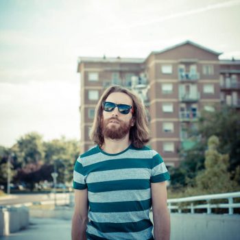 stylish hipster model with long red hair and beard lifestyle in the street