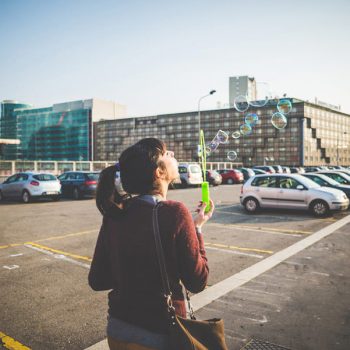 young beautiful hipster woman bubble blower in the city