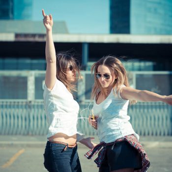two beautiful young women dancing in the city