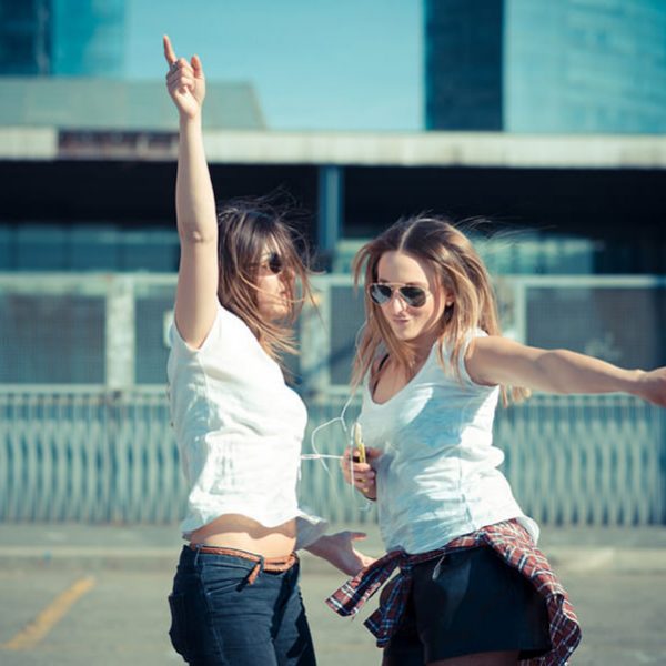 two beautiful young women dancing in the city